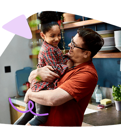 Father holding toddler and playing with toddler daughter