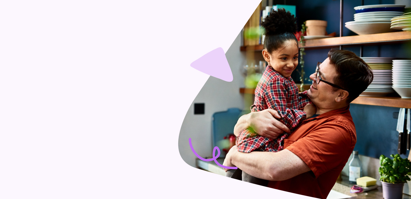 Father holding toddler and playing with toddler daughter