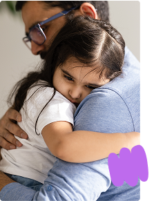 Father holding and comforting toddler daughter who is ill